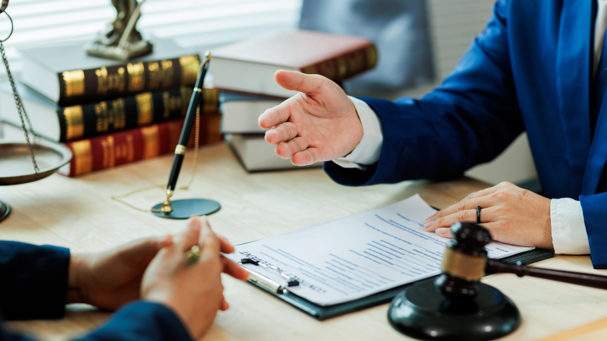 Lawyer consulting client at office desk.