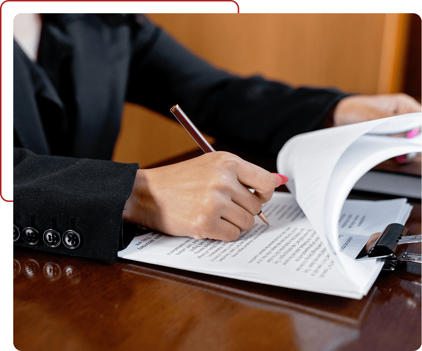 Person reviewing documents and taking notes with a pencil.